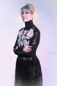 Grey hair model Valeria Sechi wearing a dress with floral embroidery