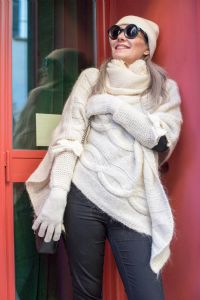 Grey hair model Valeria Sechi wearing a white wool sweater gloves and sunglasses