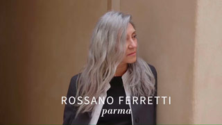Valeria Sechi a mezzo busto, appoggiata a una parete con una spalla, nella campagna per Rossano Ferretti Parma