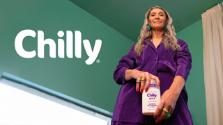 Ritratto dal basso di Valeria Sechi in completo viola nella campagna social per Chilly