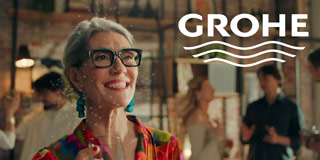 Primo piano di Valeria Sechi in abito floreale con occhiali neri nello spot per Grohe