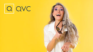 Ritratto di una Valeria Sechi sorridente con camicia bianca su fondo giallo per QVC Italia