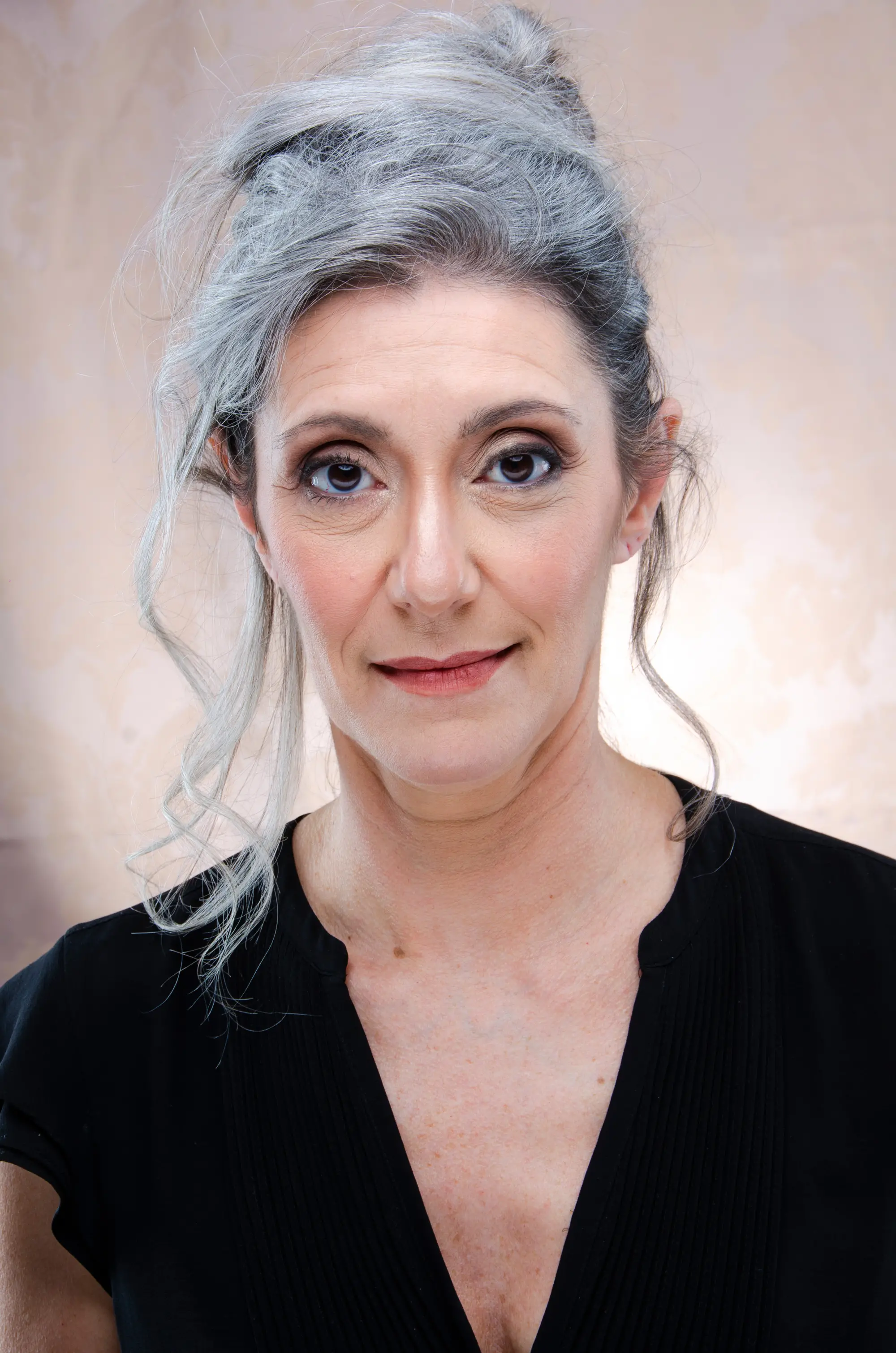 Ritratto beauty di Valeria Sechi, modella italiana dai capelli grigi naturali — sguardo diretto, abito nero, fondo neutro