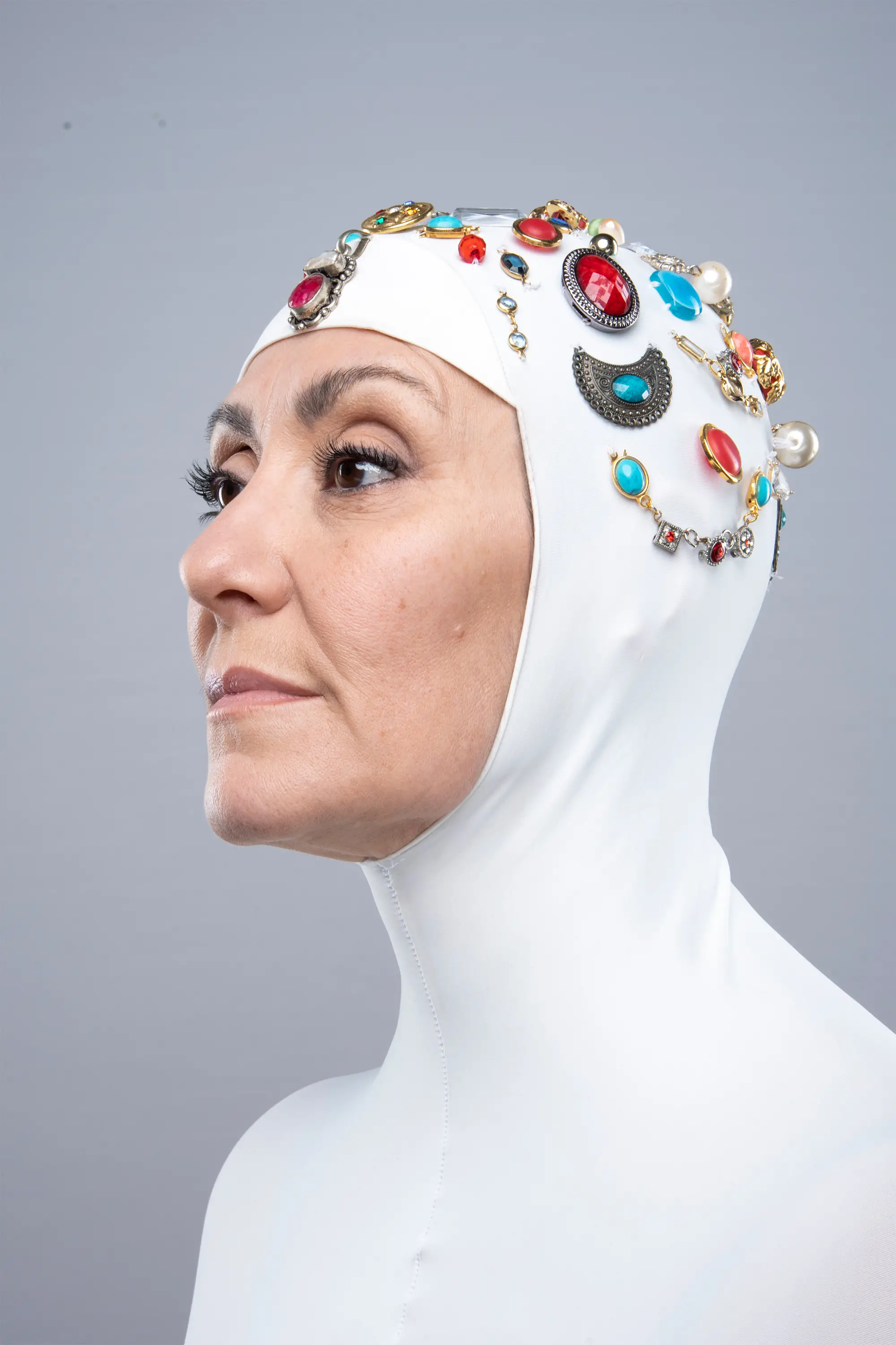 Valeria Sechi in scatto editorial: balaclava bianco coperto di gioielli, profilo, progetto fashion-forward