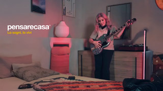 Fotogramma dello spot di Pensare Casa, Valeria Sechi in una camera da letto mentre imbraccia una chitarra elettrica