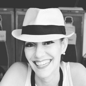 A black and white portrait of grey hair model Valeria Sechi with a white hat