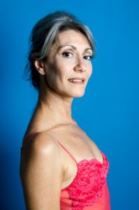 A portrait of grey hair model Valeria Sechi with a blue background