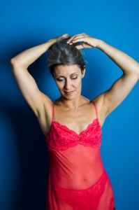 A portrait of grey hair model Valeria Sechi with a blue background