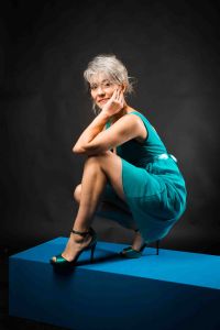 A portrait of grey hair model Valeria Sechi wth a turquoise dress