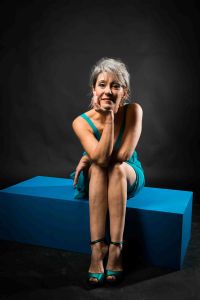 A portrait of grey hair model Valeria Sechi wth a turquoise dress