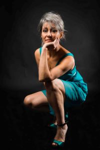 A portrait of grey hair model Valeria Sechi wth a turquoise dress