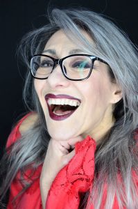 A portrait of grey model Valeria Sechi wearing black eyeglasses and smiling