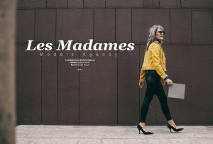 Grey hair model Valeria Sechi walking with yellow jacket and black trousers