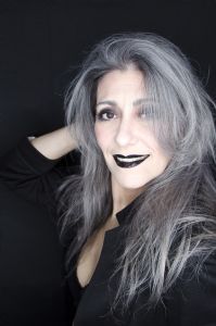 Grey hair model Valeria Sechi wearing a black jacket with dark lipstick