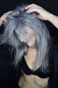 Grey hair model Valeria Sechi wearing a black jacket with dark lipstick