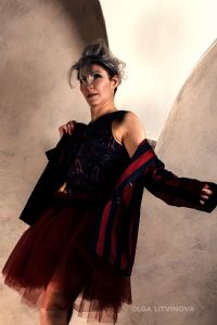 Grey hair model Valeria Sechi wearing a dark vest and a tulle skirt