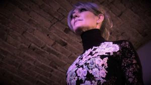 Grey hair model Valeria Sechi wearing a dress with floral embroidery