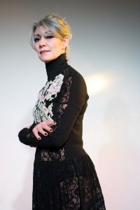 Grey hair model Valeria Sechi wearing a dress with floral embroidery