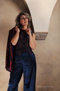 Grey hair model Valeria Sechi wearing a jacket and blue trousers