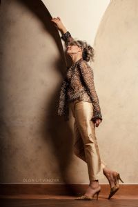 Grey hair model Valeria Sechi wearing a leopard print shirt and golden trousers