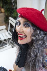 Grey hair model Valeria Sechi wearing a red hat and black gloves