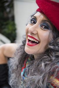 Grey hair model Valeria Sechi wearing a red hat and black gloves