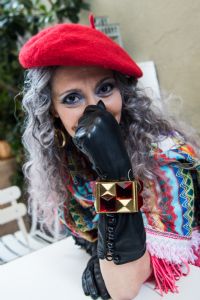 Grey hair model Valeria Sechi wearing a red hat and black gloves