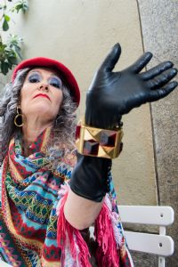 Grey hair model Valeria Sechi wearing a red hat and black gloves