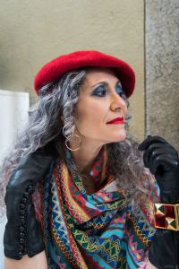 Grey hair model Valeria Sechi wearing a red hat and black gloves