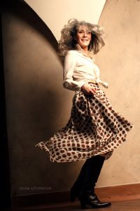 Grey hair model Valeria Sechi wearing a white fashion shirt and a pois skirt