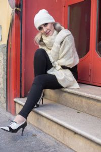 Grey hair model Valeria Sechi wearing a white wool sweater and gloves