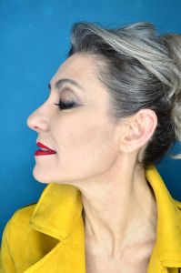 Grey hair model Valeria Sechi wearing a yellow leather jacket