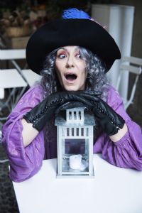 Grey hair model Valeria Sechi wearing gloves and a hat with feathers