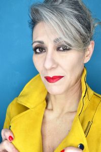 Grey hair model Valeria Sechi wearing a yellow leather jacket