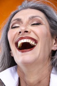 Italian grey hair model Valeria Sechi with a white shirt on an orange background